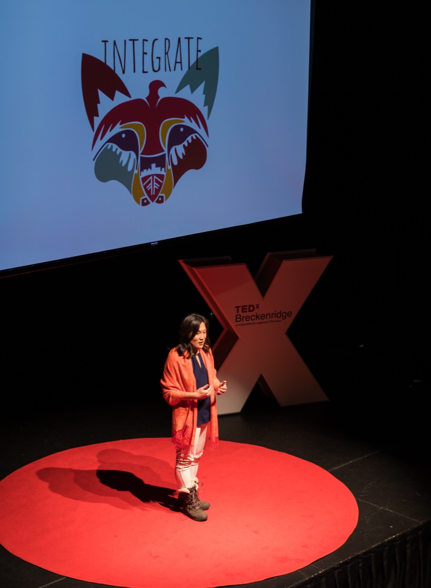 Wide view of TEDxBreckenridge event from the audience perspective showing speaker on stage