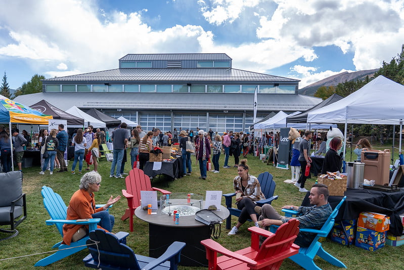 Speaker sharing ideas on the red TEDxBreckenridge stage