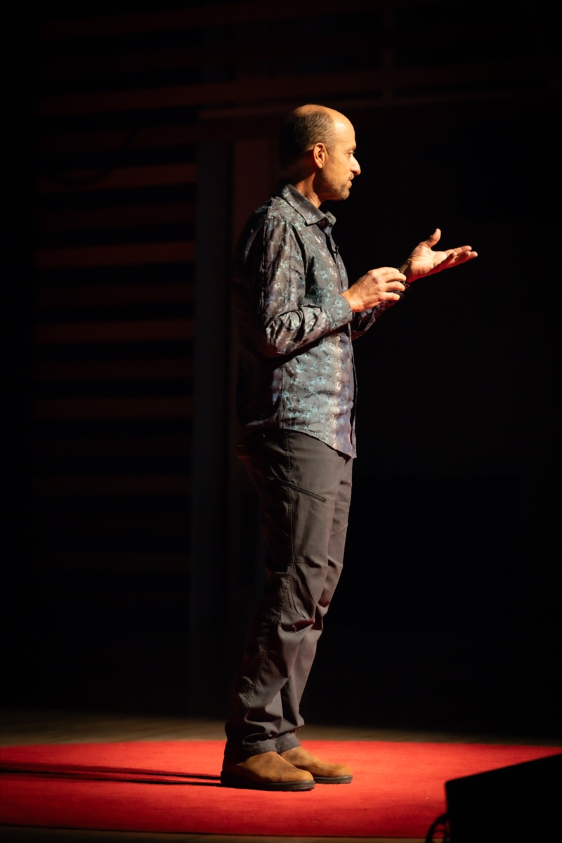 TEDxBreckenridge speaker delivering their talk on the iconic red dot stage