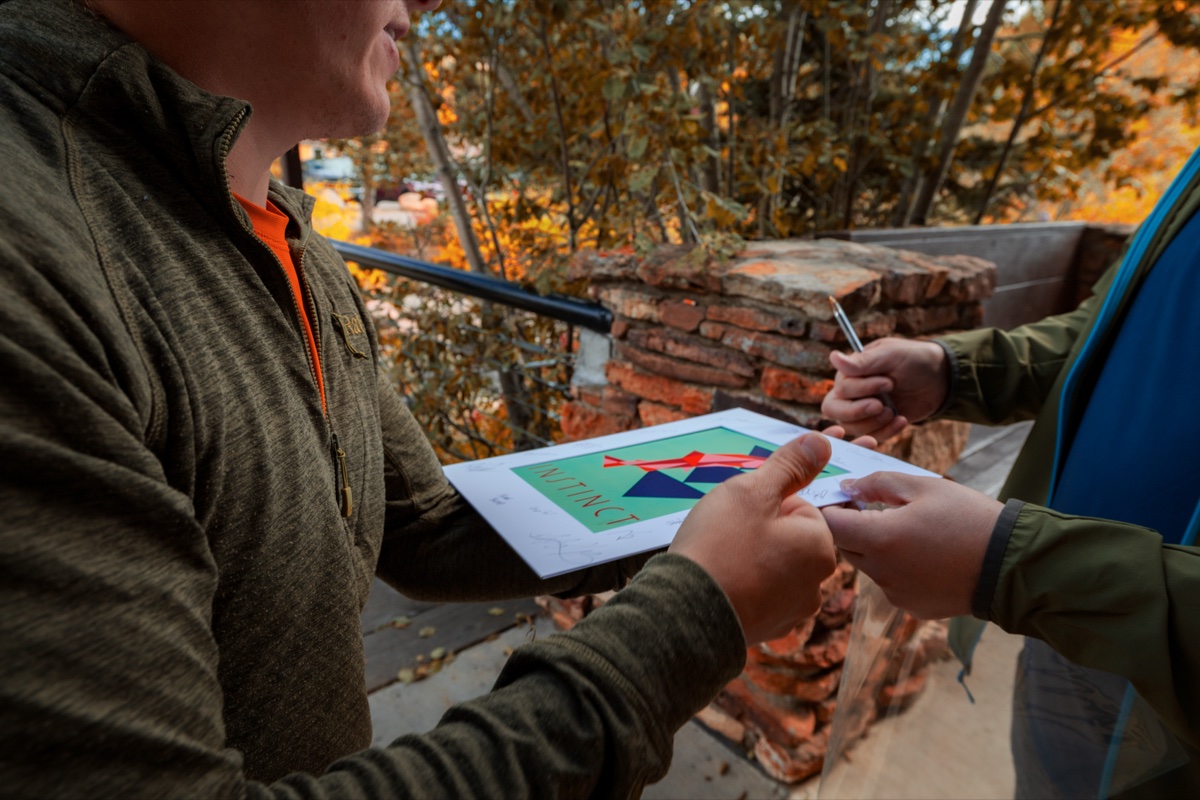 TEDxBreckenridge speaker signing a poster after their talk, showing post-event engagement and impact